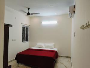 a bedroom with a bed with a red blanket at Rudraksha RESIDENCY in Tiruvannāmalai