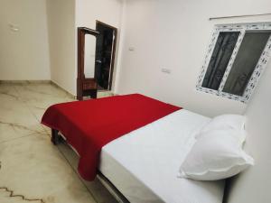 a bedroom with a bed with a red blanket at Rudraksha RESIDENCY in Tiruvannāmalai