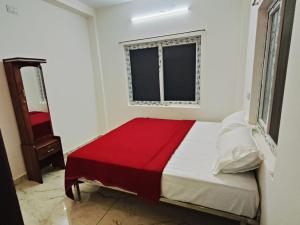a bedroom with a bed with a red blanket at Rudraksha RESIDENCY in Tiruvannāmalai