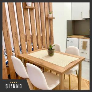a dining room table with white chairs and a plant on it at Rio Studio by Sienna in Skopje