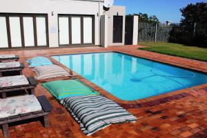 a swimming pool with pillows laying around it at Ellefsen Golf Suite 115, Langebaan, 4-sleeper in Langebaan