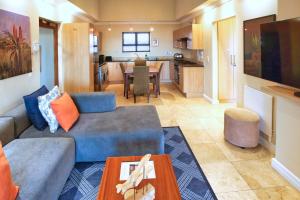a living room with a couch and a dining room at Ellefsen Golf Suite 115, Langebaan, 4-sleeper in Langebaan