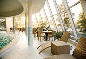 Duży pokój z basenem, stołami i krzesłami w obiekcie Yyteri Spa Hotel w mieście Pori