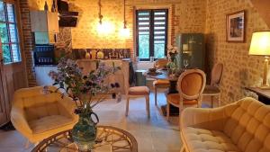 ein Wohnzimmer mit einem Tisch und einer Blumenvase in der Unterkunft Ancien moulin dans un cadre d exception in Ferrières-la-Verrerie