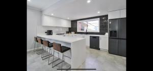 a kitchen with a white counter and some chairs at Buzzin' in Hay