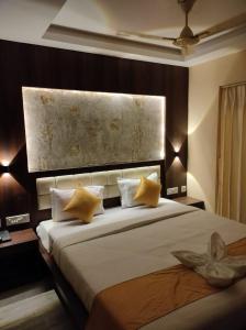 a bedroom with a large bed with yellow pillows at The Royal Sea A Unit of Adi Group of Hotel And Resort in Digha