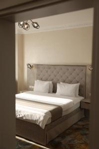 a bedroom with a large bed with white sheets at Hotel France in Vinnytsya
