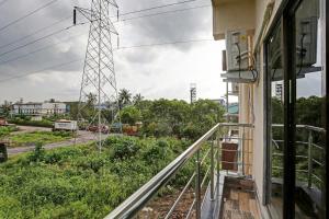 einen Balkon eines Hauses mit einem Stromturm im Hintergrund in der Unterkunft Hotel Om Sai residency in Taloje