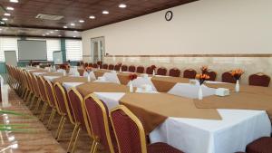 a conference room with tables and chairs and a screen at Khani Hotel in Duhok