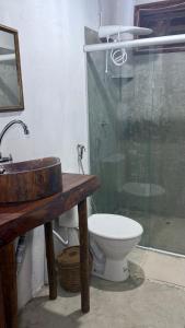 a bathroom with a toilet and a sink and a shower at Suítes Independentes em Trancoso in Trancoso +8 photos