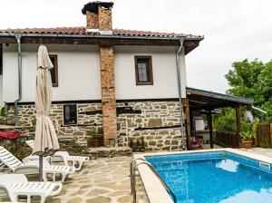 a house with a swimming pool next to a building at Къща за гости Ножери in Tryavna