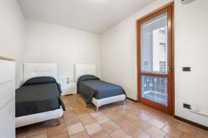 a bedroom with two beds and a window at Villa Arcadia Apartments in Vobarno