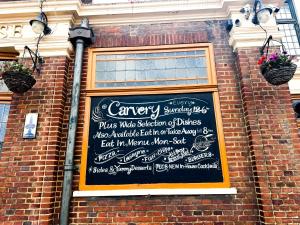 a chalkboard sign on the side of a brick building at The Eastbrook Pub & Hotel in Dagenham