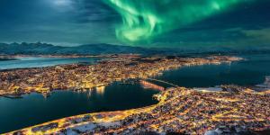 an aerial view of a city with the aurora in the sky at Modern and Stunning House View in Tromsø