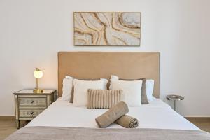 a bedroom with a large white bed with two pillows at Yas Island 2BR | Pool | Near Ferrari World & Mall in Abu Dhabi +76 photos