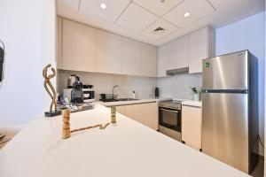 a kitchen with a stainless steel refrigerator at Chic Family 2br, Canal Views! Near Ferrari World in Abu Dhabi