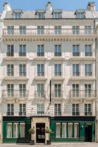 a large white building with green doors and windows at Hotel Monge in Paris