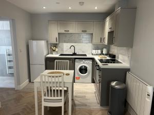 a kitchen with a stove and a sink and a dishwasher at The Loft in Merthyr Tydfil