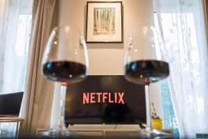 two glasses of red wine in front of a television at Studio near Bristol w/ garden & parking in Flax Bourton