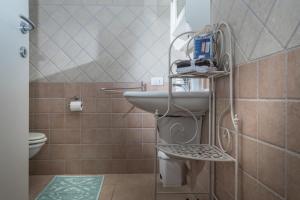 a bathroom with a sink and a toilet at Ananas villa Porto Pozzo in Porto Pozzo +37 photos