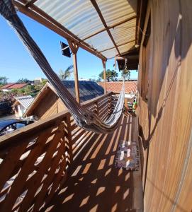 a porch with a hammock on the side of a building at Cabana 02 superior in Imbituba