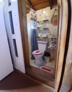 a bathroom with a toilet in a small room at Cabana 02 superior in Imbituba