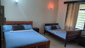 a room with two beds and a window at Serena Beach Road Apartment in Mombasa