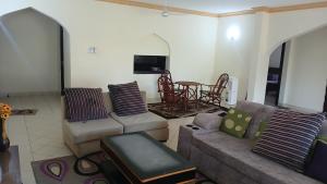 a living room with two couches and a table at Serena Beach Road Apartment in Mombasa