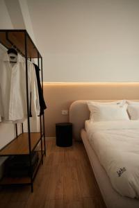 a bedroom with a bed and a rack of clothes at Lake side story in Frumuşani +23 photos