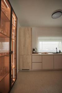 a kitchen with white cabinets and a window at Lake side story in Frumuşani
