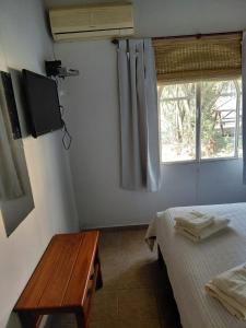 a room with a bed and a table and a window at Cabaña 4B Azahares del Ayui in Concordia +11 photos