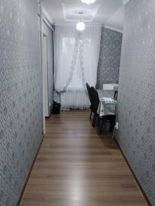 a hallway with a table and chairs and a window at White cute house in Karakol +5 photos