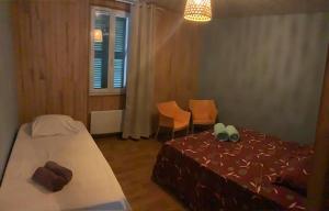 ラランスにあるEscapade Ossau 6 personnes à Larunsのベッドとテーブルと椅子のある寝室
