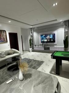 a living room with a pool table and a tv at Luxury 3 Bedroom Apartment Lekki IKATE in Lekki