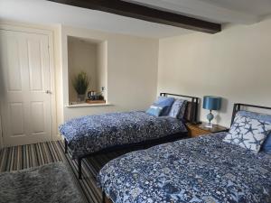 a bedroom with two beds with blue and white sheets at Unicorn Hotel Llanidloes in Llanidloes