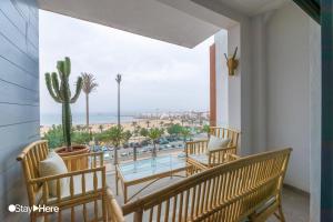 a balcony with chairs and a view of the ocean at StayHere Agadir - Marina Residential Living in Agadir