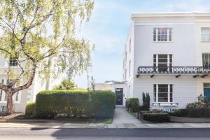 a white house with a tree in front of it at 15 Pittville Lawn in Cheltenham