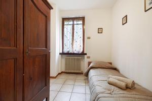 salon z dwoma łóżkami i oknem w obiekcie Villetta Arcadia Corallo w mieście Vobarno