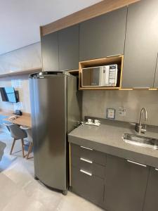 een keuken met een roestvrijstalen koelkast en een magnetron bij Studio no condomínio Almagah SPaulo in Sao Paulo