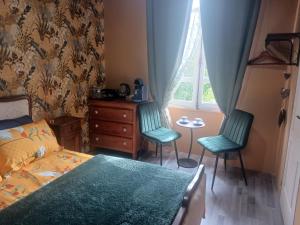 a bedroom with two chairs and a bed and a window at Cherry Blossom House in Bujaleuf