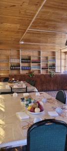 a long table with a plate of fruit and wine bottles at Hotel Sarytag in Sarytag
