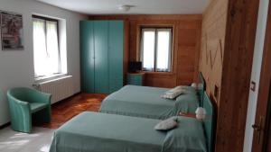 a bedroom with two beds and a blue cabinet at Mont Gelé in Ollomont