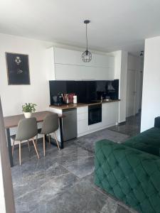 a kitchen and a living room with a table and chairs at Star apartman 3 in Novi Pazar +15 photos