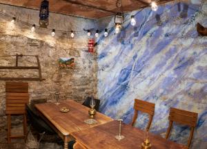 two tables and chairs in a room with a stone wall at Chalet à thème, 2 chambres, vue sur les montagnes in Chalais