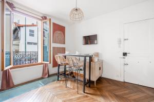 a dining room with a table and chairs and a window at Charming cocon, well-located Apartment 2 rooms in Malakoff