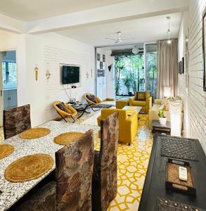 a living room with a couch and a table at Siboney House by evaddo in Siolim