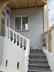 a white house with stairs and a window at Apartman MATEA in Pirot