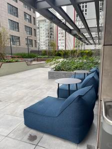 een terras met blauwe stoelen en een tafel en gebouwen bij Studio no condomínio Almagah SPaulo in Sao Paulo