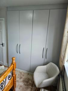 a living room with white cabinets and a chair at Enniscrone Guest Rooms in Enniscrone