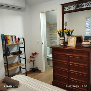 a bedroom with a dresser and a mirror at El ático de la Cañada in Frigiliana